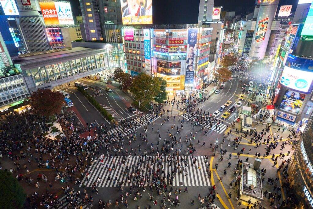 Crowds crossing the Shibuya scramble intersection at night in Tokyo