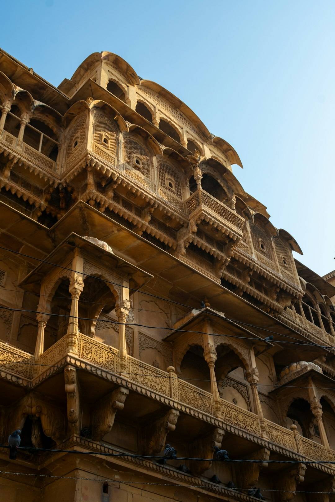 Intricate carved sandstone facade of a Rajasthan haveli, jharokha windows in fine stone lace