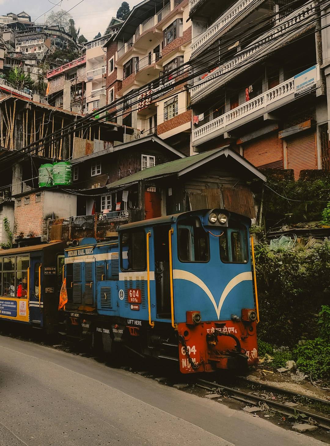 The blue Darjeeling Himalayan Railway toy train passing through town