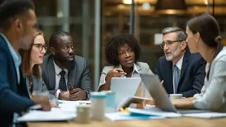 Diverse professionals in a corporate business meeting discussing work over laptops