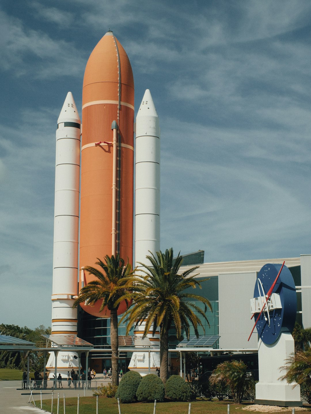 A NASA space shuttle rocket on display with palm trees at Kennedy Space Center, Florida