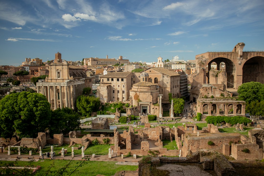 Ancient Roman Forum ruins with standing columns beneath a blue sky