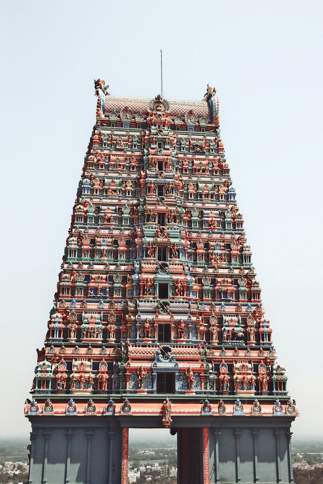 Elaborately carved gopuram tower covered in painted deity figures at the Meenakshi temple, Madurai