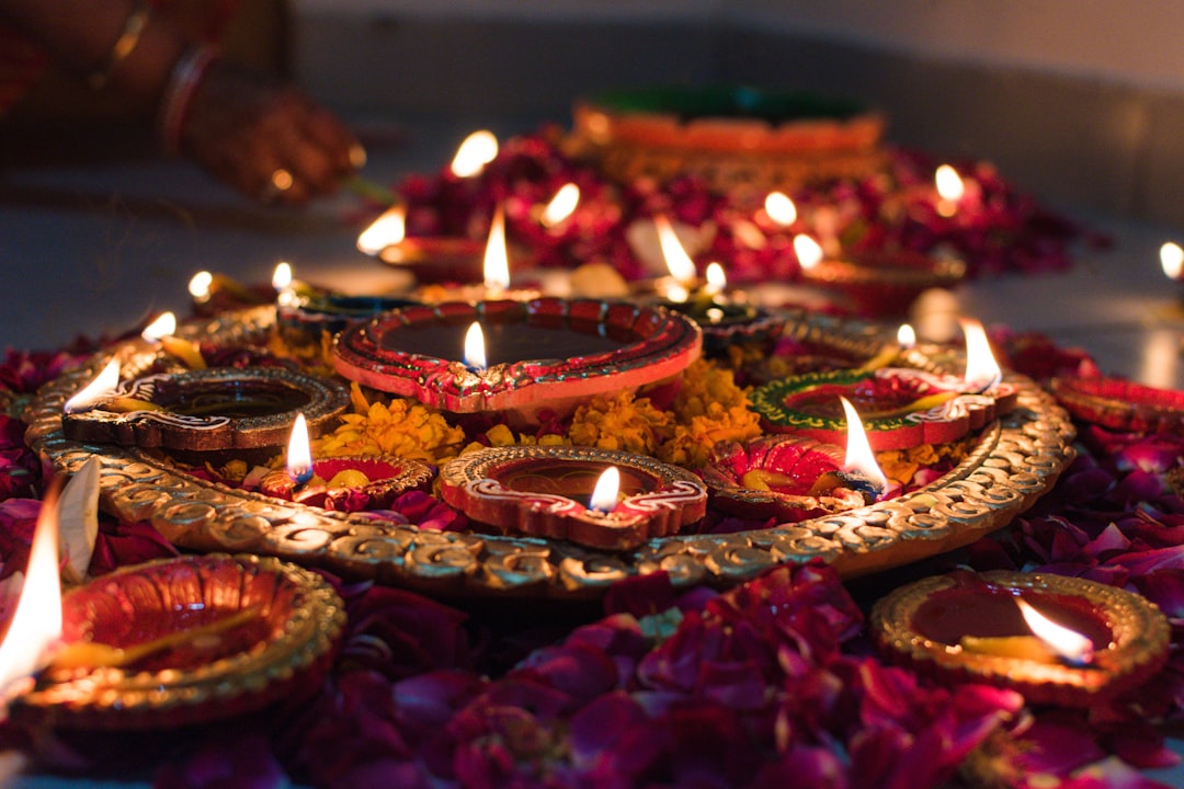 Lit clay diya oil lamps arranged with flower petals for the quiet Diwali morning after Narkasur