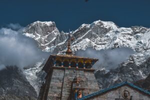 Stone Himalayan temple set against snow-capped peaks, evoking Kedarnath