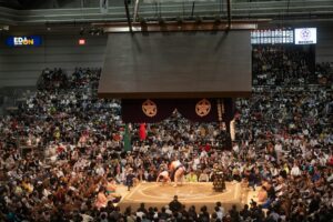 Sumo wrestlers competing in a packed arena during a honbasho tournament in Japan