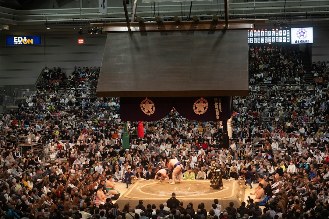 Sumo wrestlers competing in a packed arena during a honbasho tournament in Japan