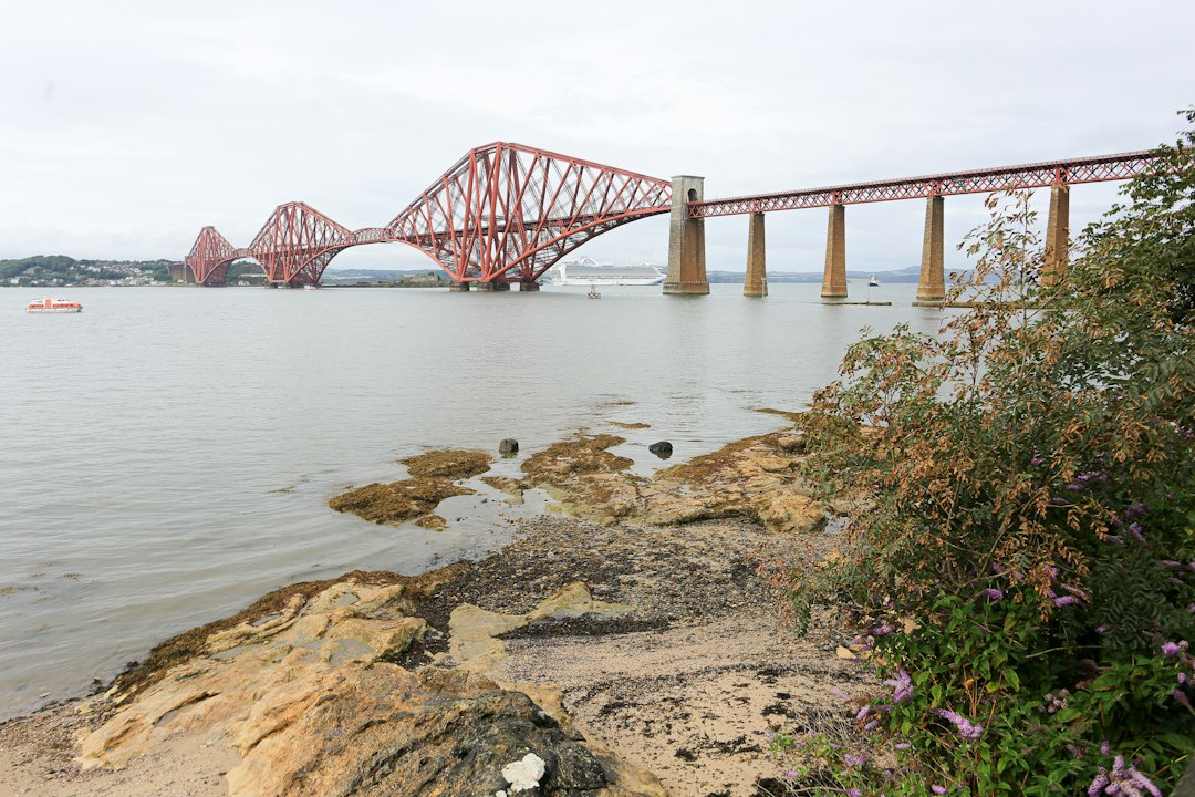 The red Forth Bridge spanning the calm waters near South Queensferry, Scotland