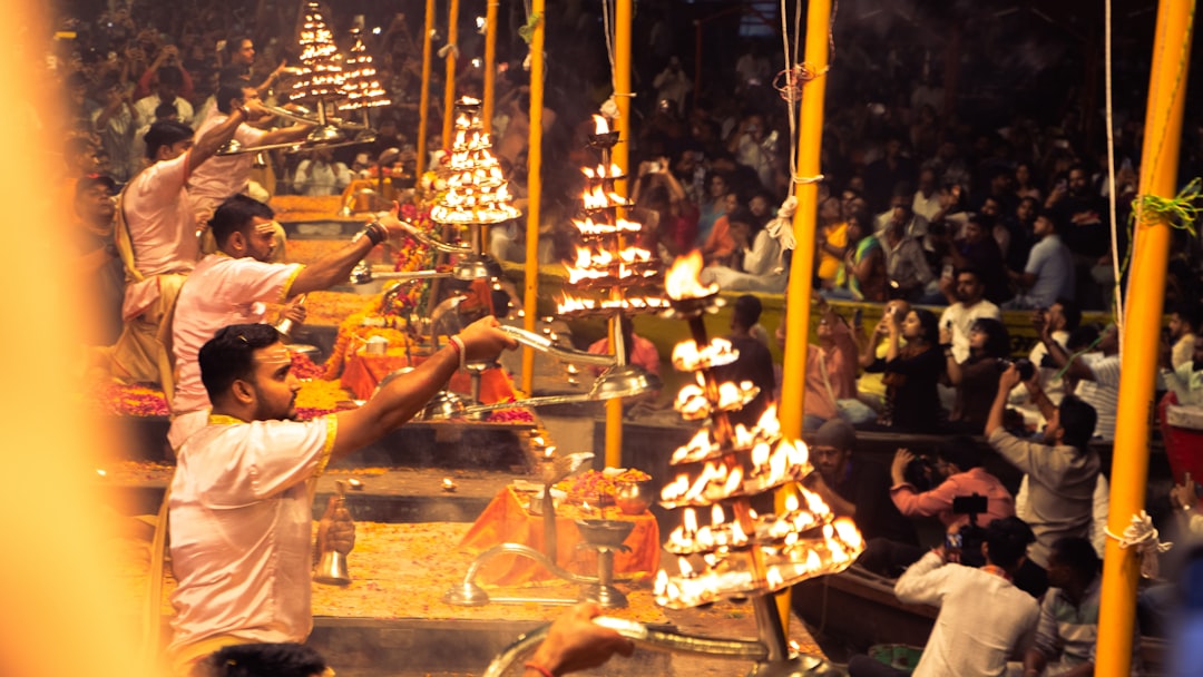 Volunteers performing an aarti ritual with lit lamps at night during Deepotsav